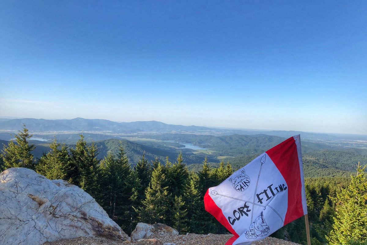 a view from a mountain top with a CoreFit flag planted slightly right of center